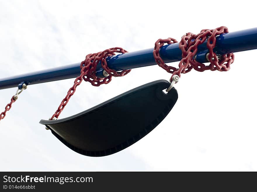 Black playground swing wound around a blue metal pole