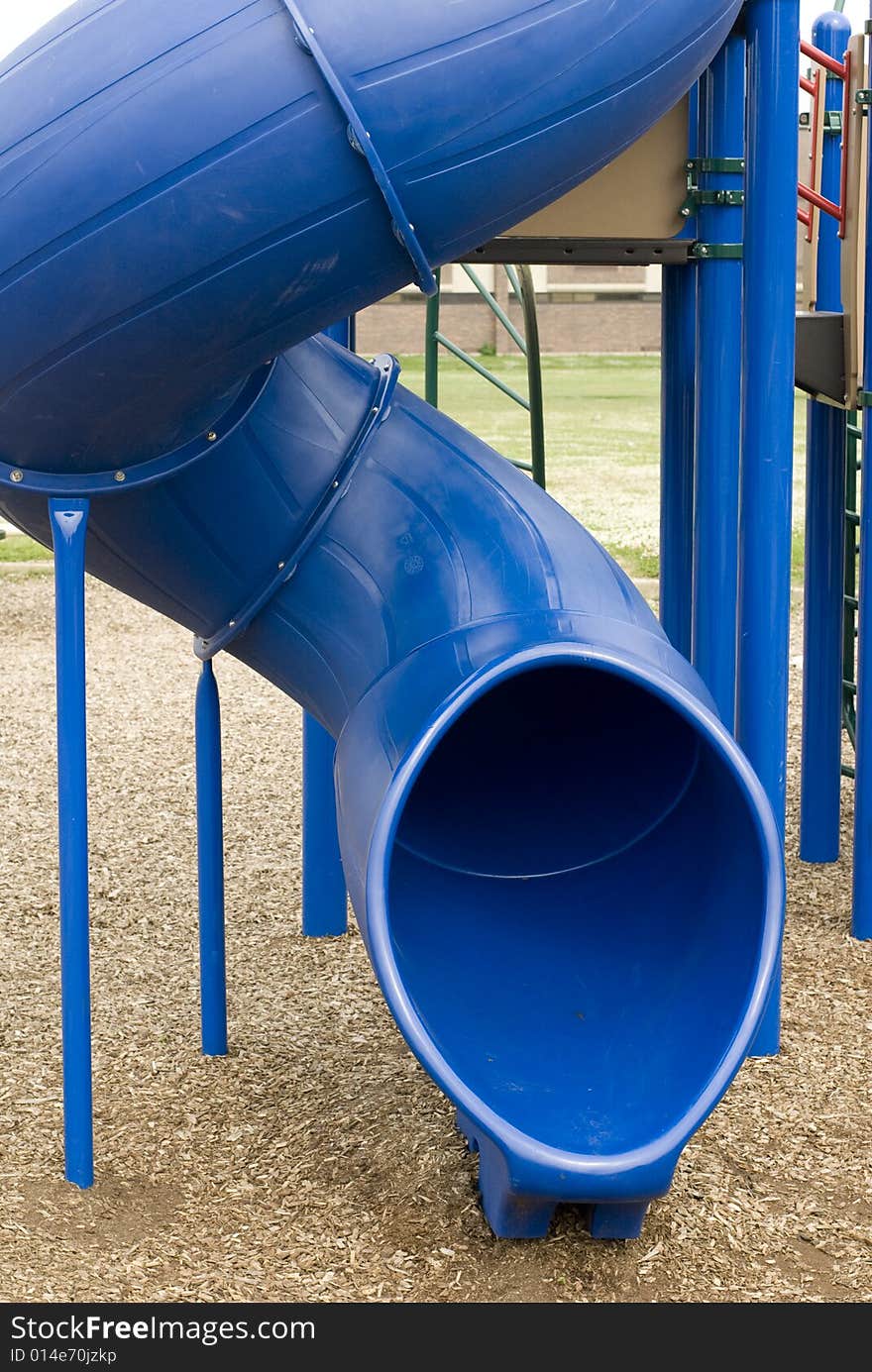 Frontal view of a playground's blue plastic slide. Frontal view of a playground's blue plastic slide