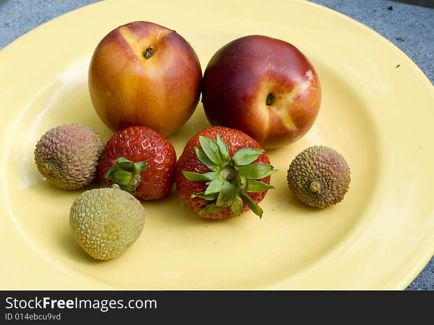 Nectarines, strawberries and lychees on a plate. Nectarines, strawberries and lychees on a plate