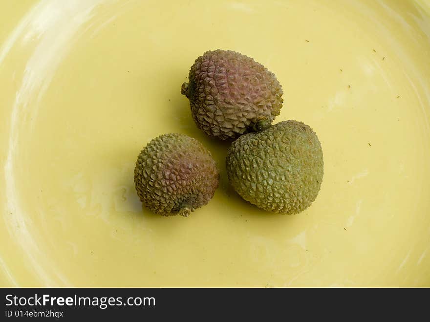 Image of a group of lychee's on a yellow plate