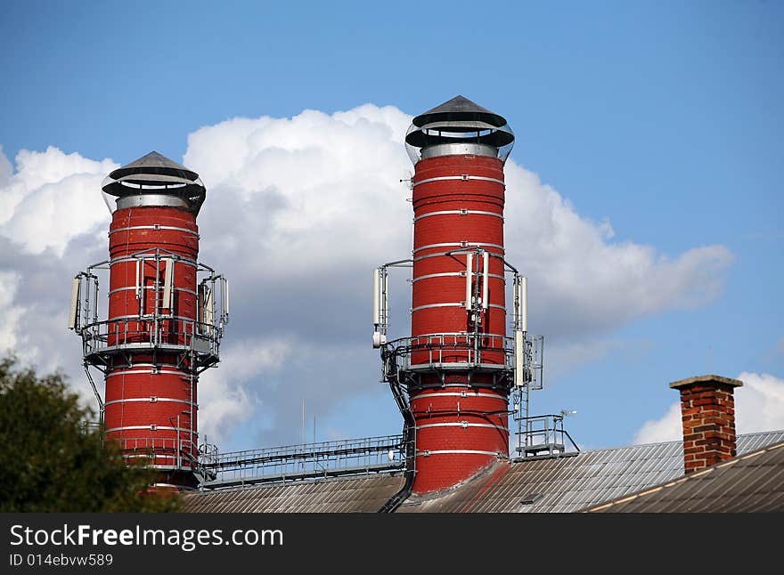 Two big red chimney of brewery and one small chimney in summer. Two big red chimney of brewery and one small chimney in summer