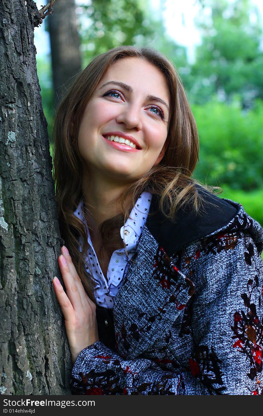 Portrait of the girl near to a tree