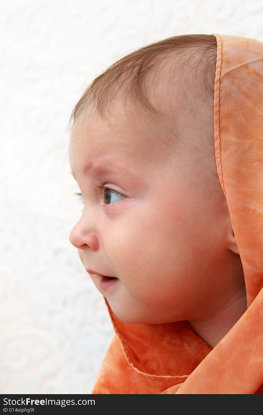 Little baby wrapped in orange shawl