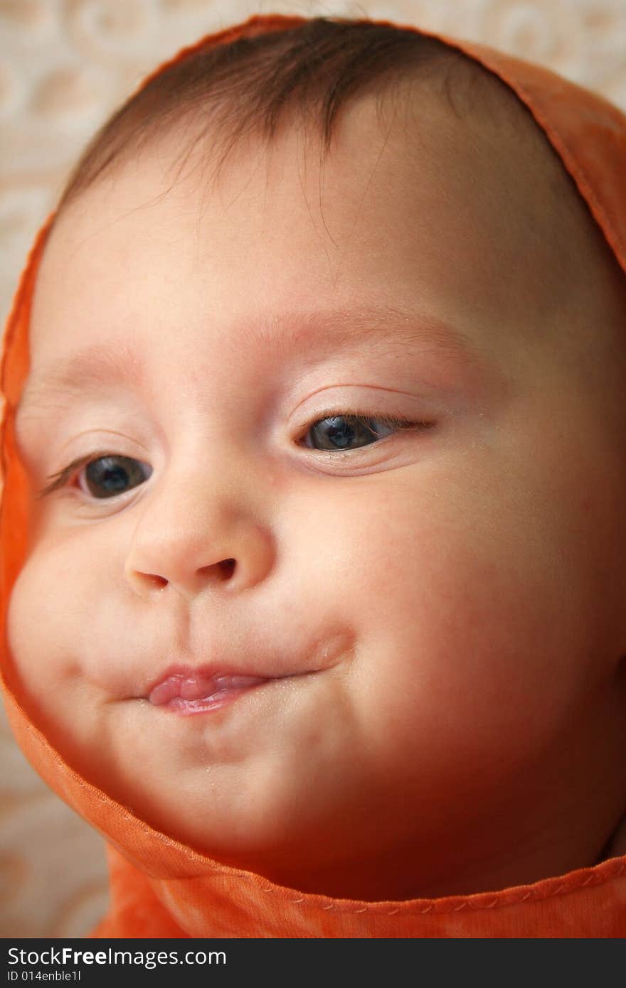 Little baby wrapped in orange shawl