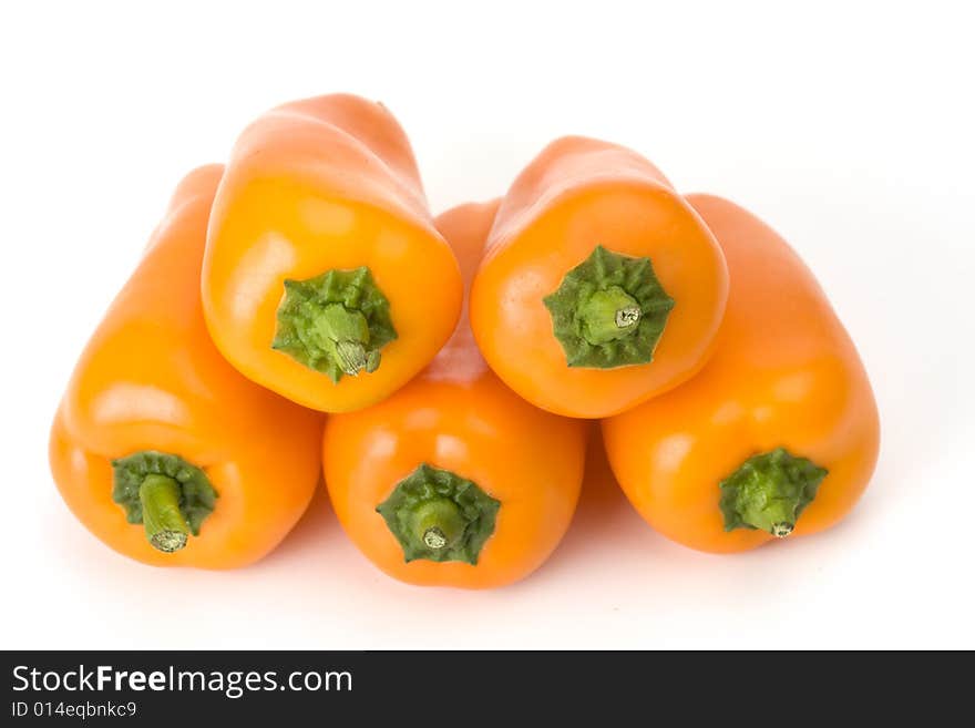 Five orange bell peppers on white background