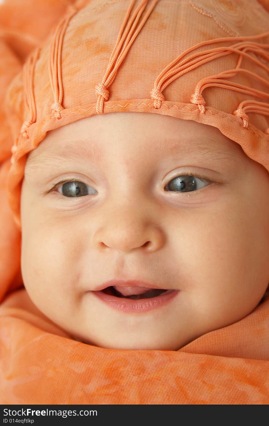 Little baby wrapped in orange shawl