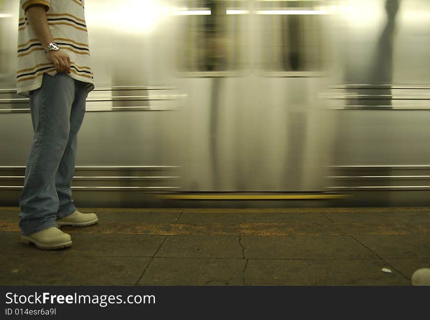 A man waiting on the platform when subway train arrives. A man waiting on the platform when subway train arrives