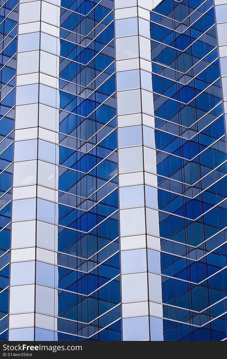 A tall modern skyscraper of blue and grey glass. A tall modern skyscraper of blue and grey glass