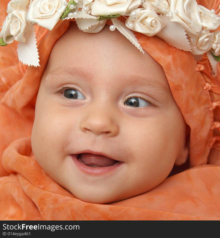 Little baby wrapped in orange shawl