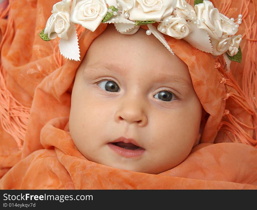 Little baby wrapped in orange shawl