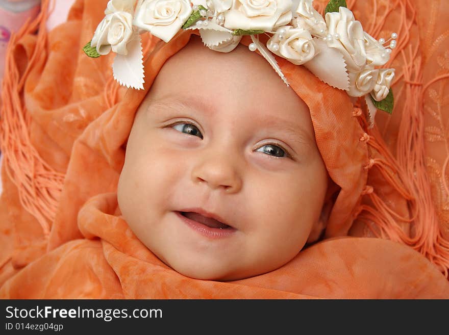 Little baby wrapped in orange shawl