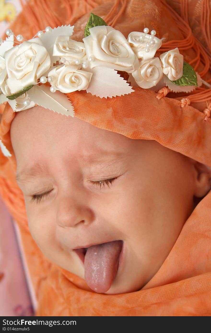 Little baby wrapped in orange shawl