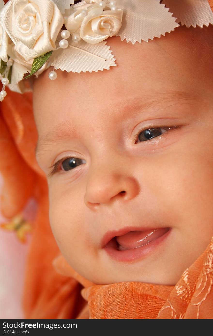 Little baby wrapped in orange shawl