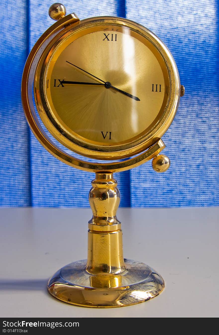 Golden table clock with blue background