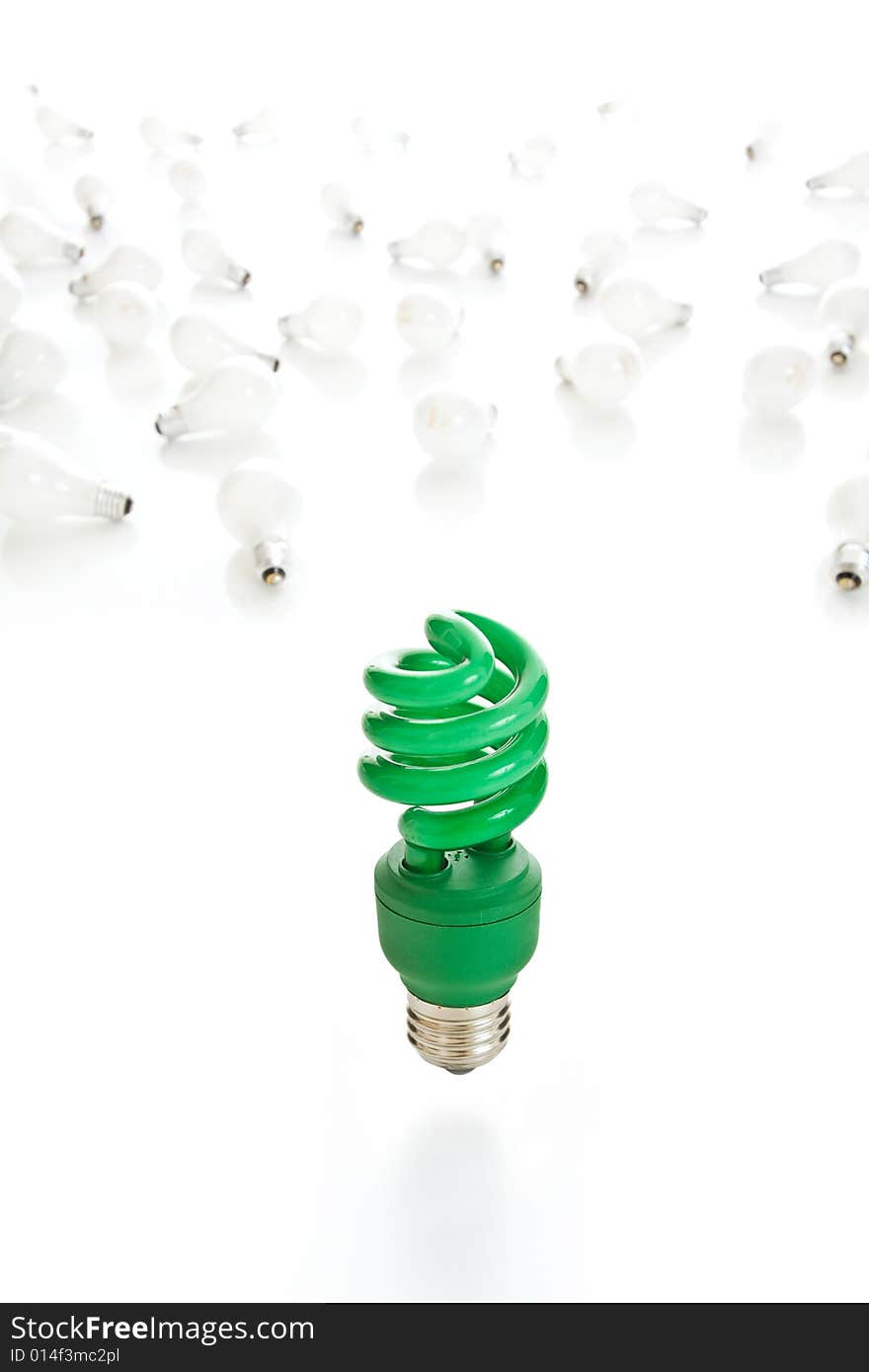 Bright green compact fluorescent light bulb in sharp focus with old incandescent bulbs littering the white background. Bright green compact fluorescent light bulb in sharp focus with old incandescent bulbs littering the white background.