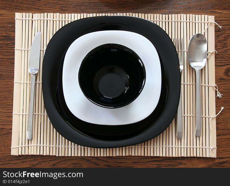 A black & white plates with utensils. A black & white plates with utensils