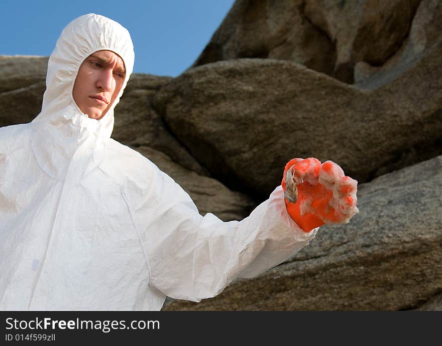 A man in protective suit holding a dead fish. A man in protective suit holding a dead fish