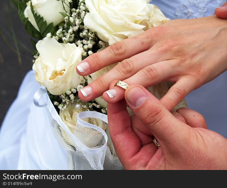 Groom putting ring on bride's finger. Groom putting ring on bride's finger