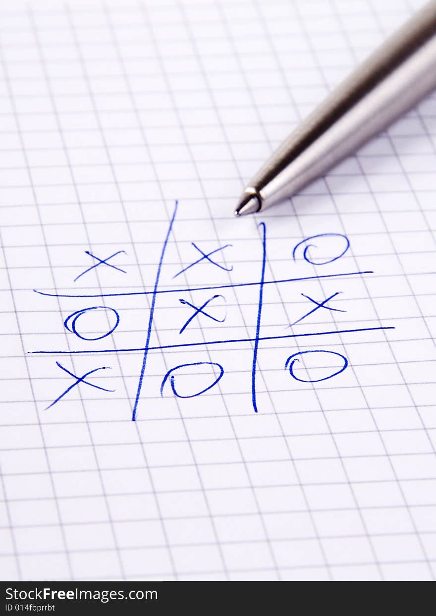 Tic Tac Toe known also as Noughts And Crosses and silver pen on notebook. Tic Tac Toe known also as Noughts And Crosses and silver pen on notebook