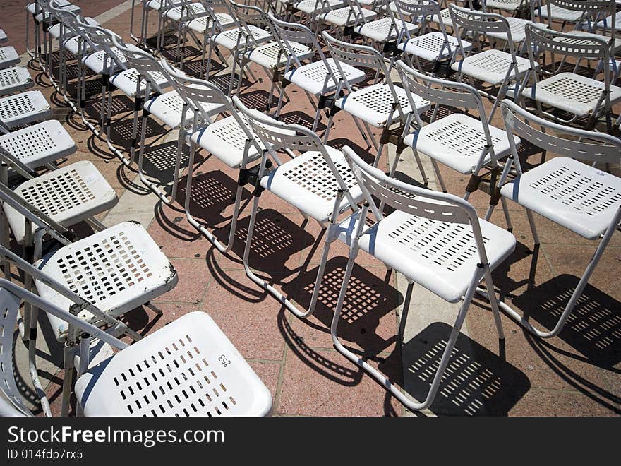 White Chairs Outdoors in the Sun and In a Row.