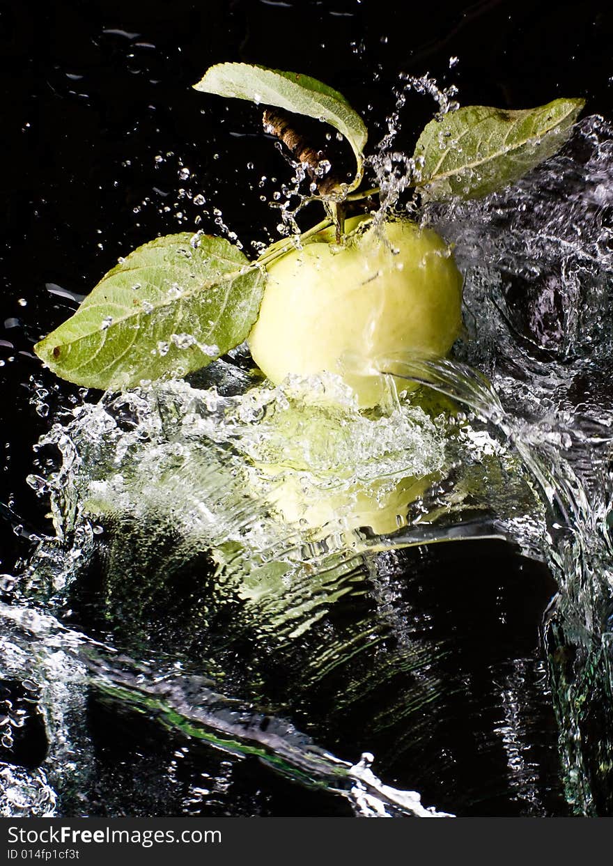 Fresh apple with water splashes on a mirror surface. Fresh apple with water splashes on a mirror surface