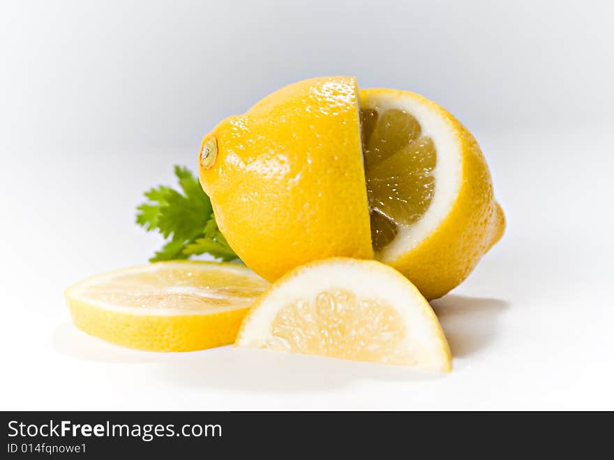 Lemons, whole and sliced, arranged on a white background.