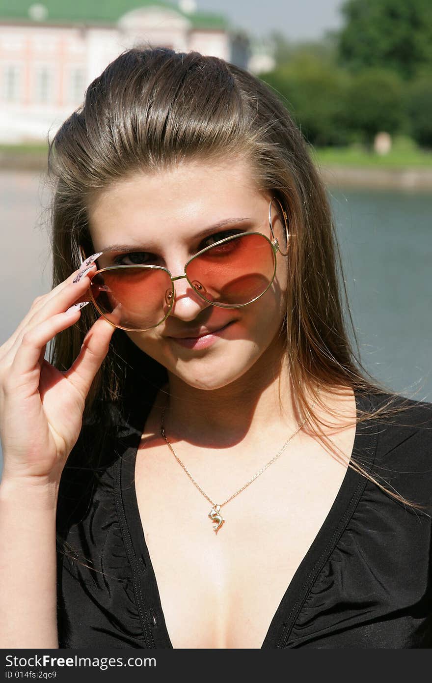 The beautiful woman in sunglasses on the nature