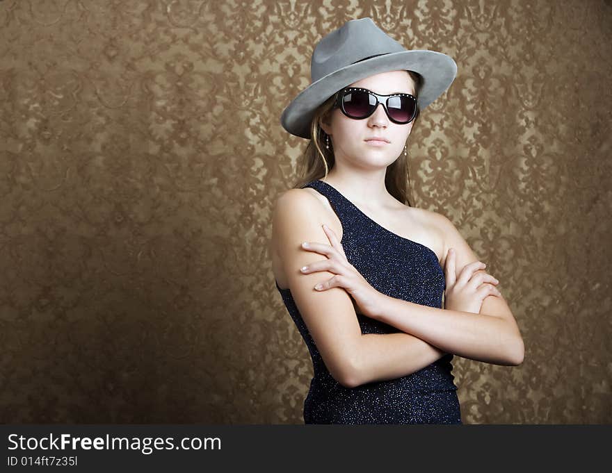 Young girl wearing a fedora and dark sunglasses. Young girl wearing a fedora and dark sunglasses