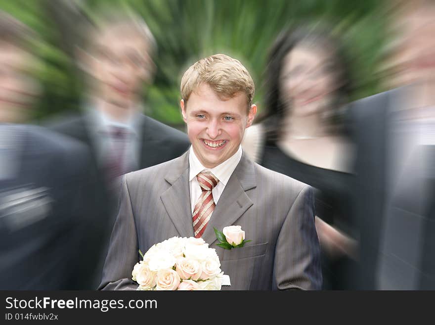 The joyful groom with a bouquet goes to the bride