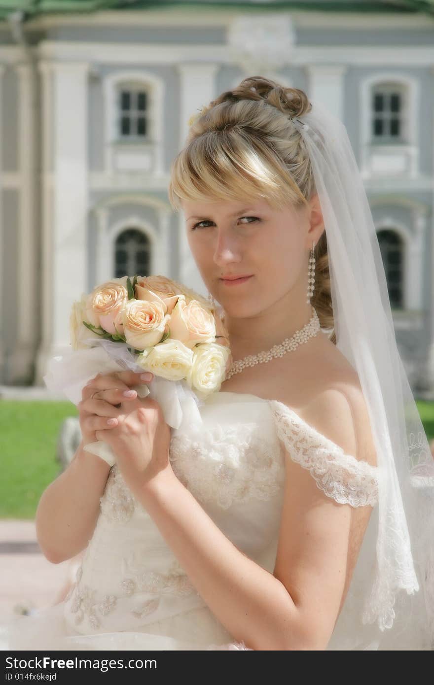 The fine bride on celebratory walk with a bouquet