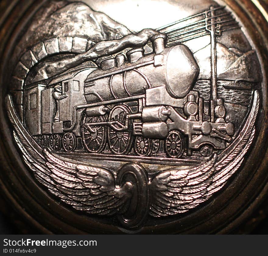 Photo of an old silver watch with a train on it. Photo of an old silver watch with a train on it.