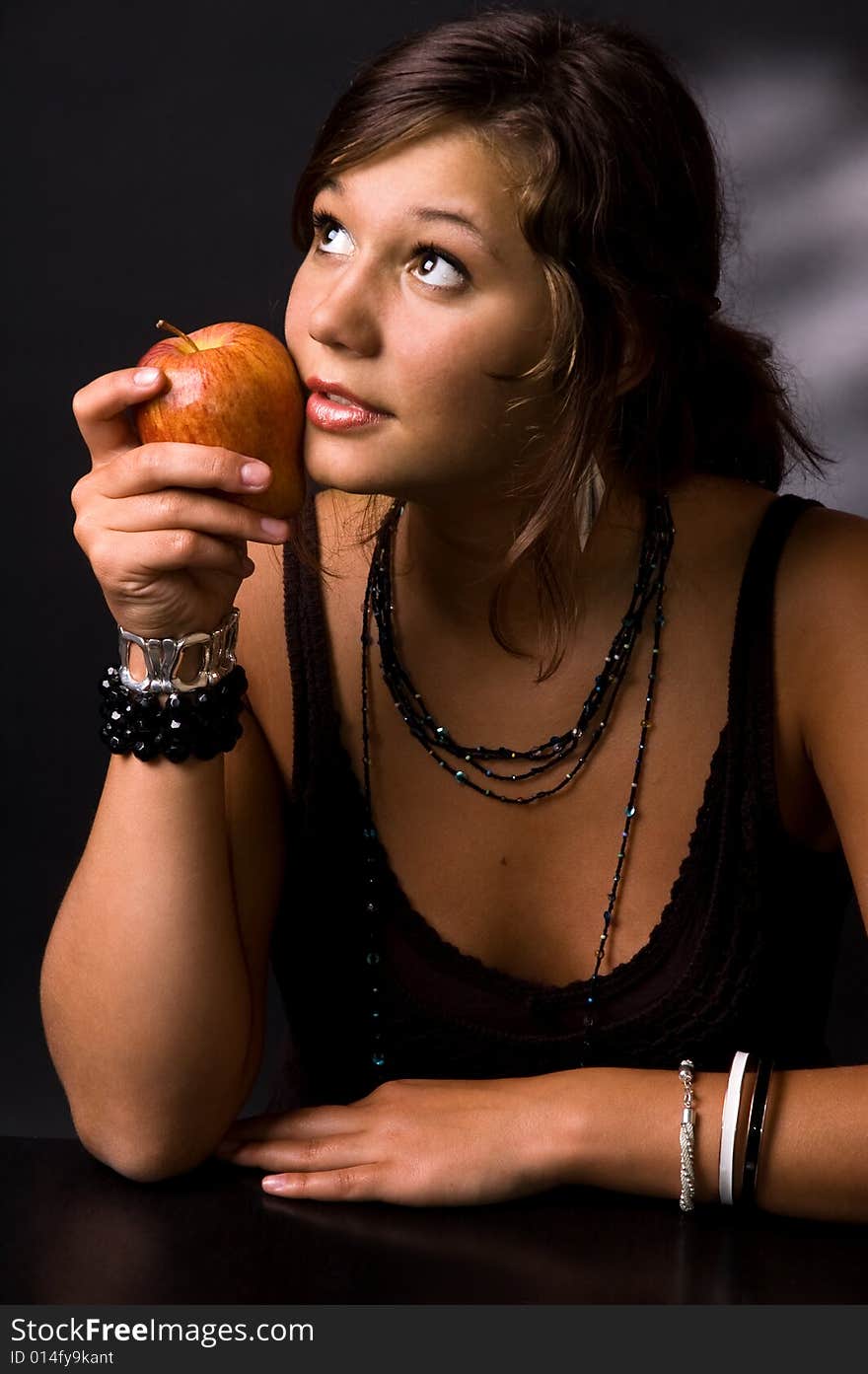 The girl with an apple on a black background