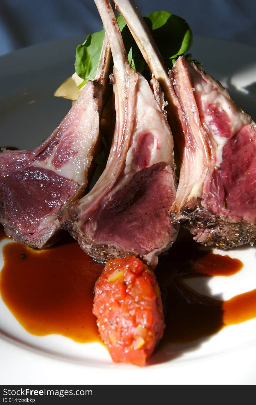 An image of gourmet lamb chops with garnishes