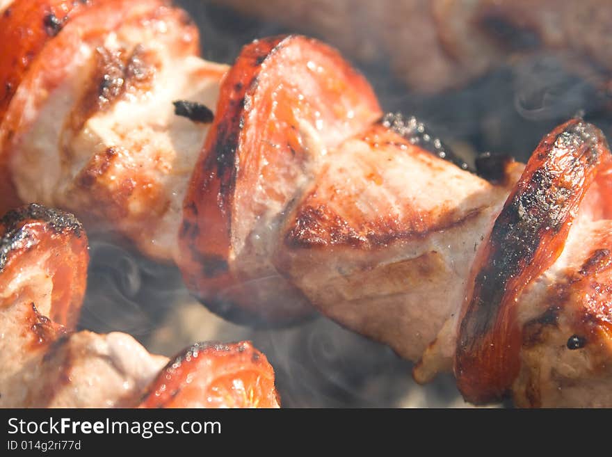 Shish kebab preparation on a brazier. Outdoor picnic. Close up.