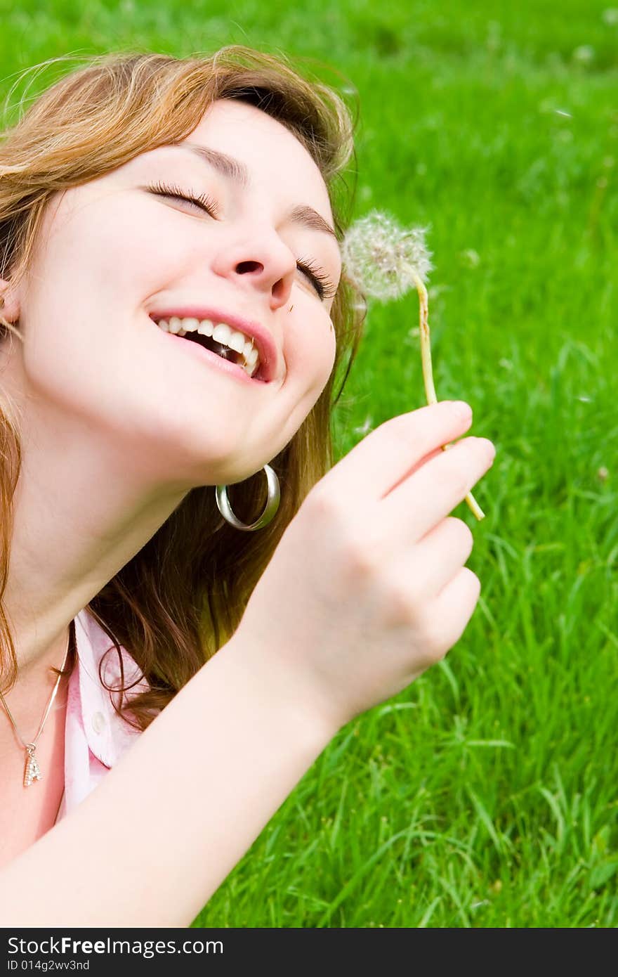 Young girl blowing on the dandelion