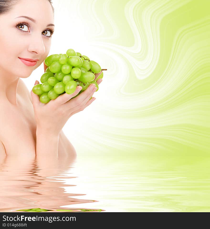 Pretty woman with green grape isolated on the white background