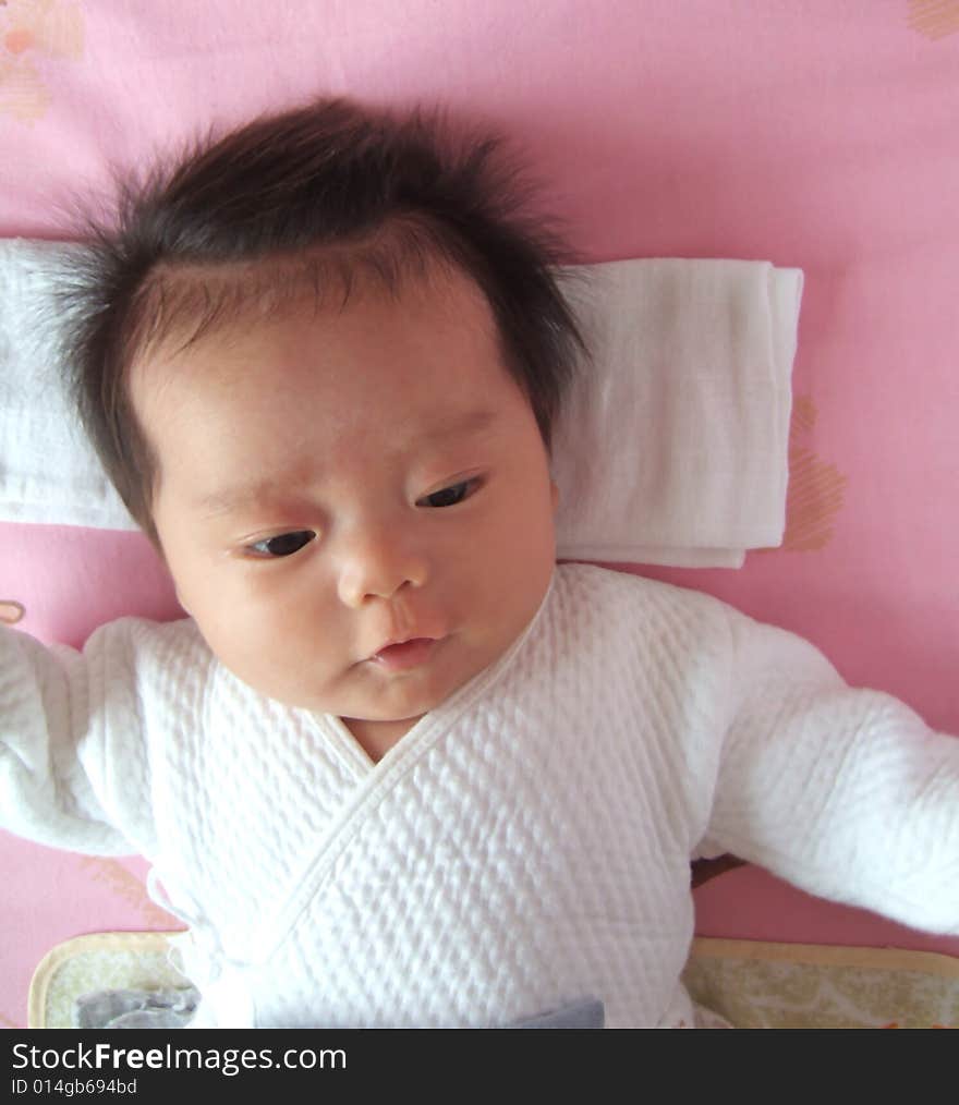 A Chinese infant on a bed. A Chinese infant on a bed