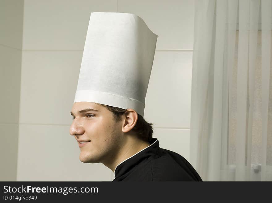 Smiling young chef in a chef's hat . Horizontally framed photo.