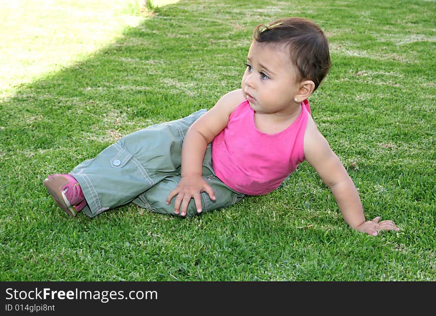 Little pretty girl in pink on green grass. Little pretty girl in pink on green grass.