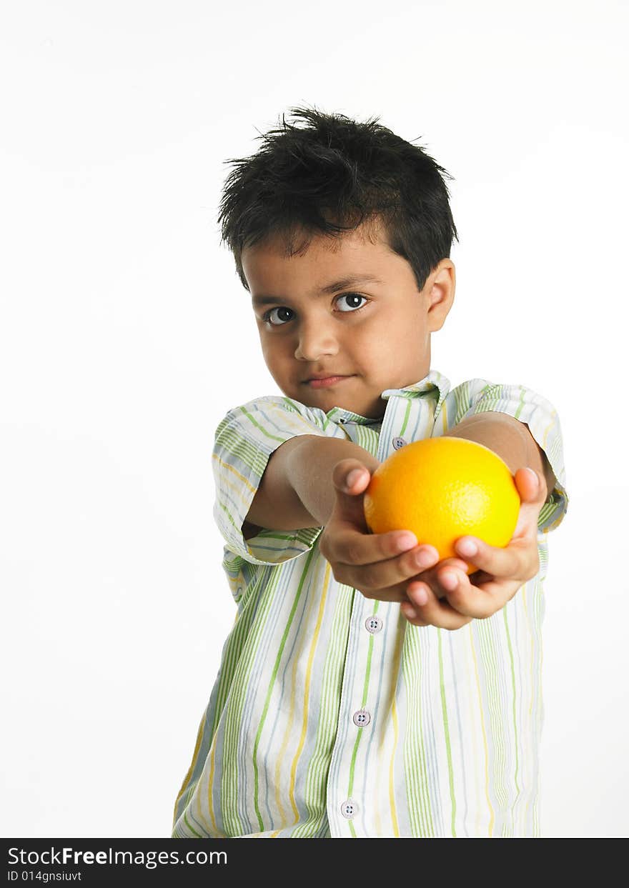 Asian boy of indian origin with an orange. Asian boy of indian origin with an orange