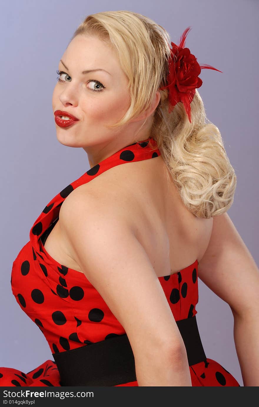 Portrait of gorgeous fifties style pinup blond in red polka-dot dress. Portrait of gorgeous fifties style pinup blond in red polka-dot dress