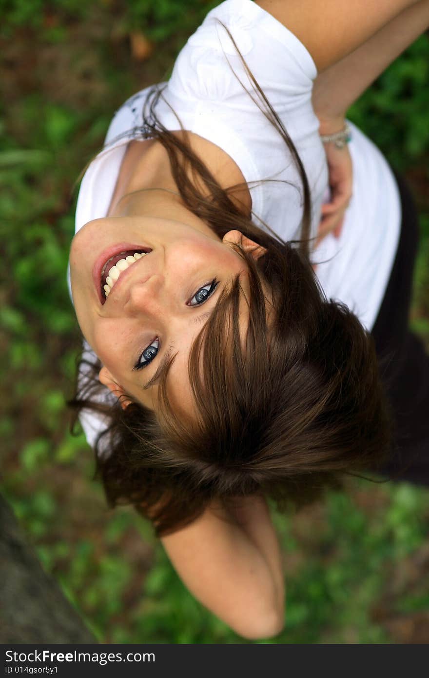 Young pretty girl smiling  on the grass.