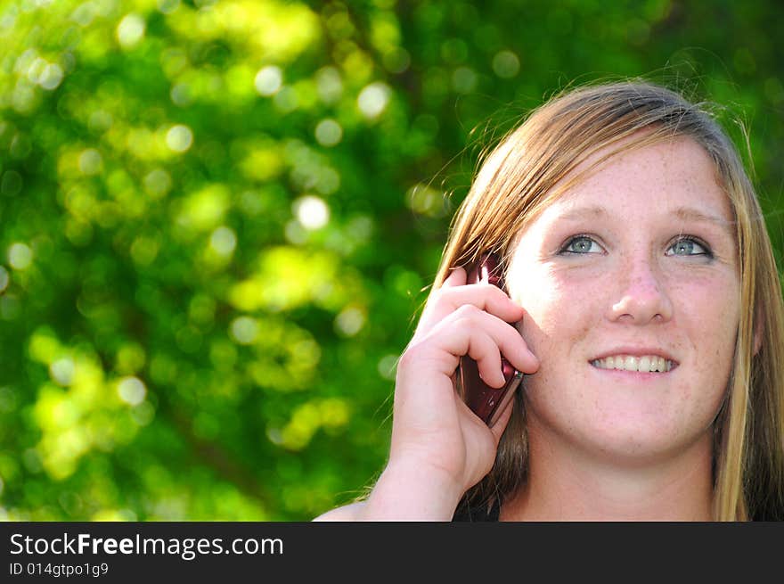 Woman talking on her cell phone in the park. Woman talking on her cell phone in the park