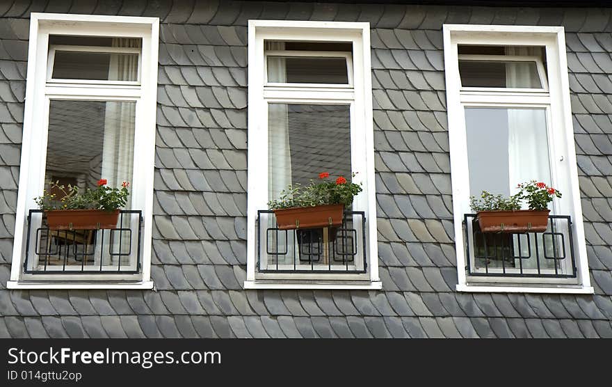 Three windows in a wall made of slate. From Goslar, Germany