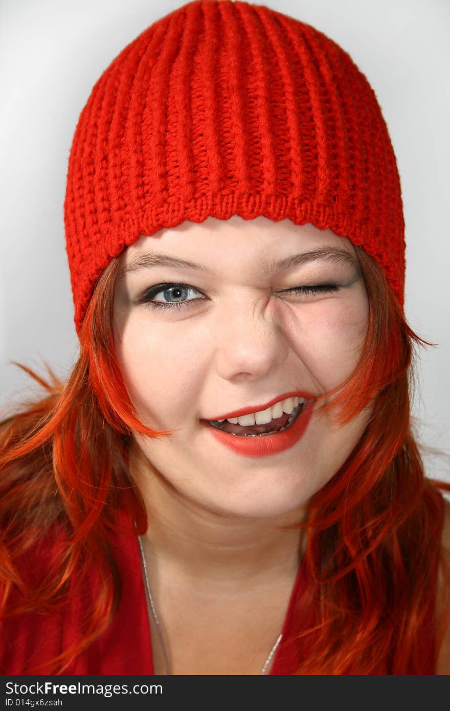 Attractive, merry girl in the red cap winks. Attractive, merry girl in the red cap winks