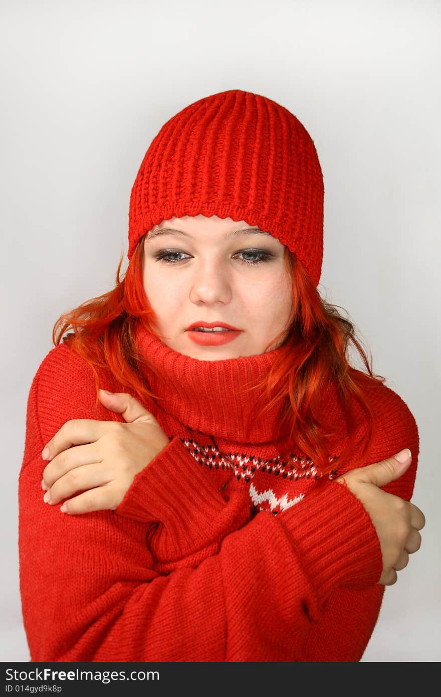 Young girl hides into the collar of the red sweater. Young girl hides into the collar of the red sweater