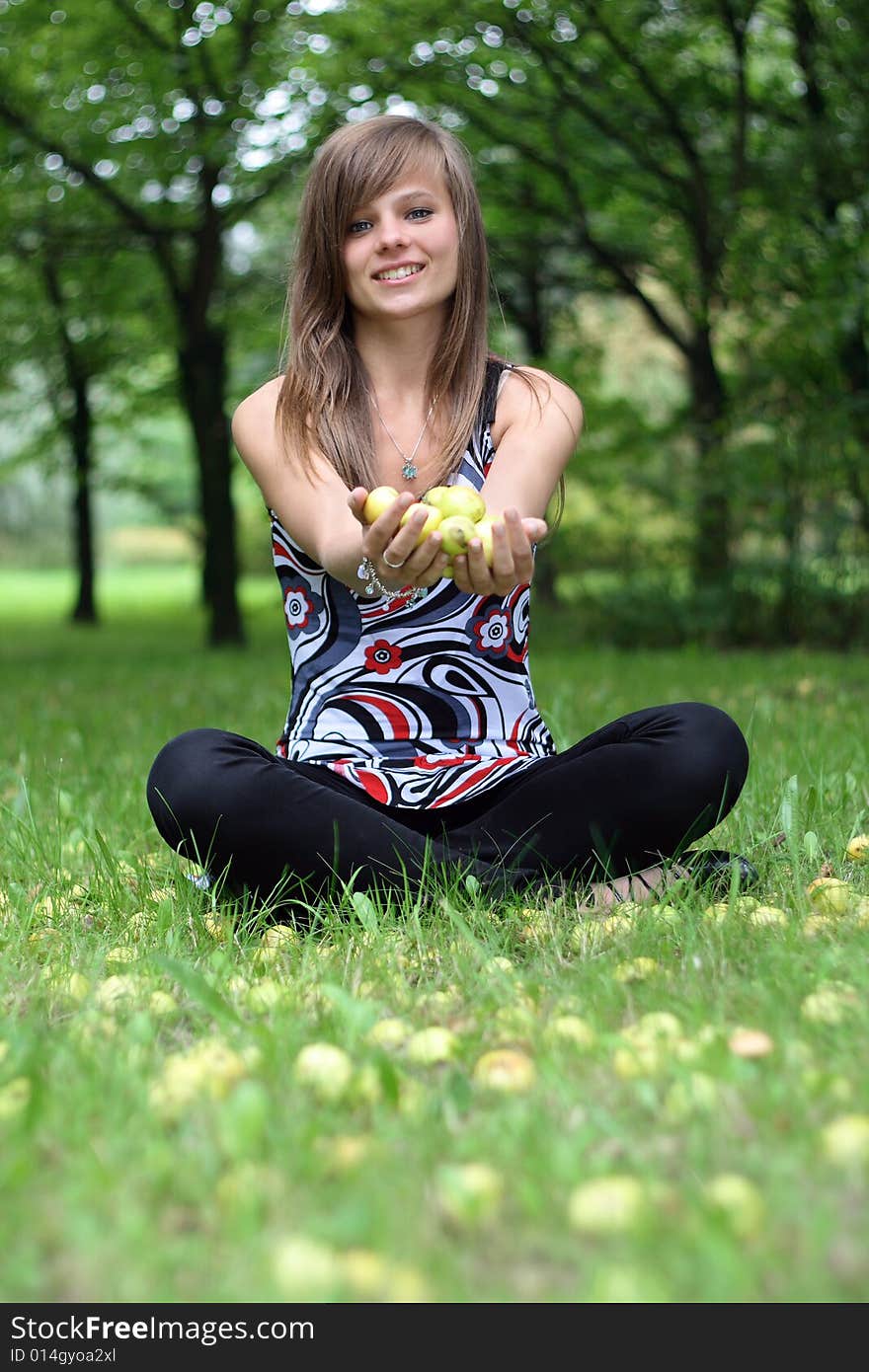 Young pretty girl with the apples on the grass