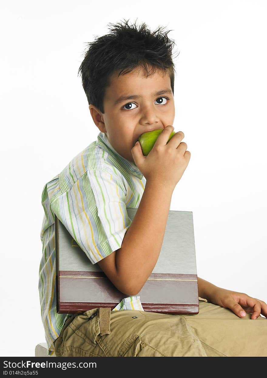 Asian boy eating a green apple