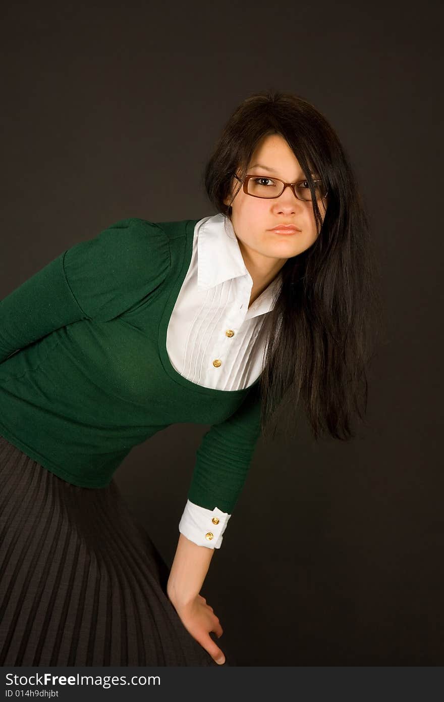 Serious looking girl dresses as teacher or businesswoman isolated on black. Serious looking girl dresses as teacher or businesswoman isolated on black