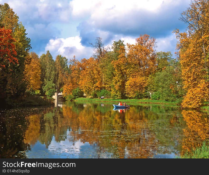 Autumn trees and pond with a boat. Autumn trees and pond with a boat